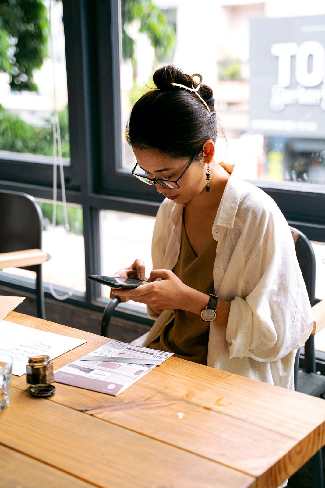 A guest using her phone at a restaurant table