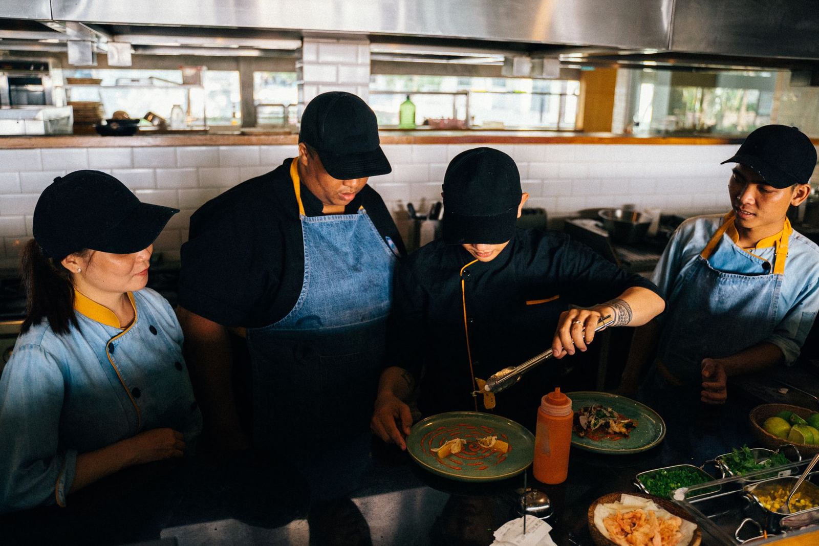 A kitchen team plating dishes during service